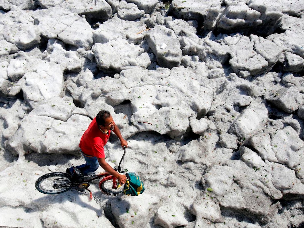 A man walks his bike on a sheet of ice on Sunday. (Ulises Ruiz/AFP/Getty)