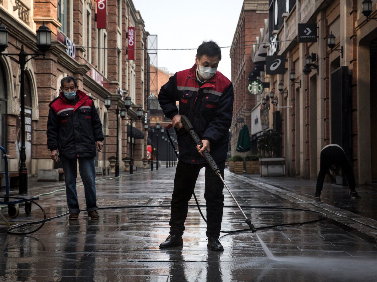 Los limpiadores lavan una calle con una pistola de agua a alta presión, 3 de febrero de 2020, Wuhan, China. (Imágenes falsas)