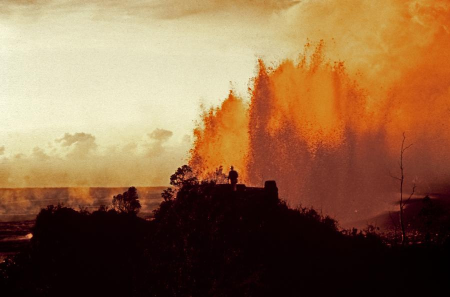 A small silhouette of a person outlined against a splash of lava in the background