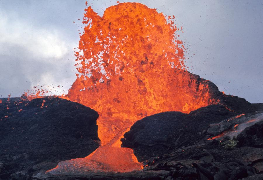 A splash of orange lava set amongst black volcanic rocks