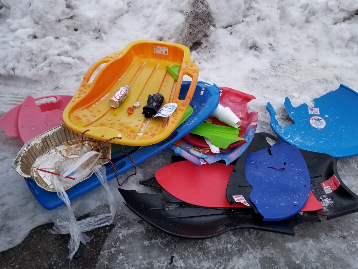 broken sleds and discarded beer cans line the snow covered ground