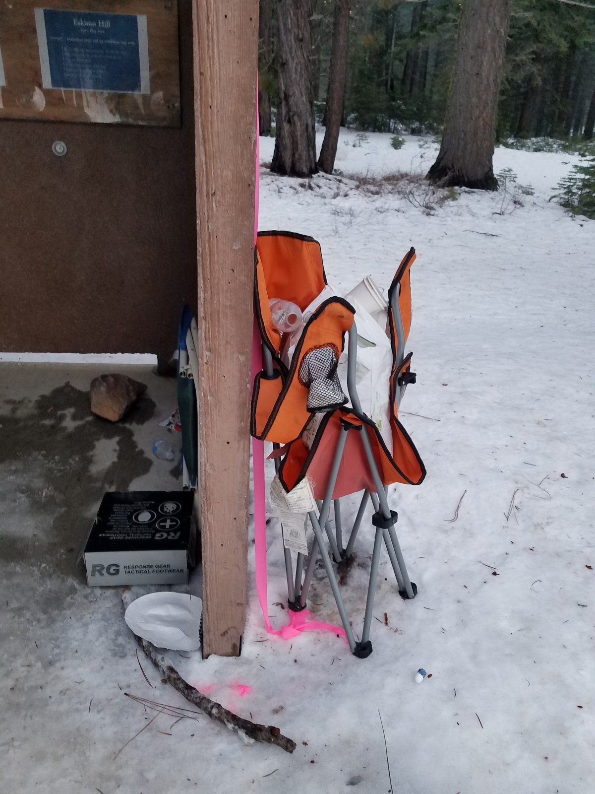 stray belongings have been pitched against the side of a restroom