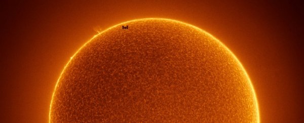 Incredible photo shows the ISS in front of a strangely spotless Sun