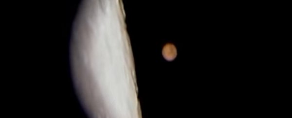 Half a moon and the planet Mars in the background