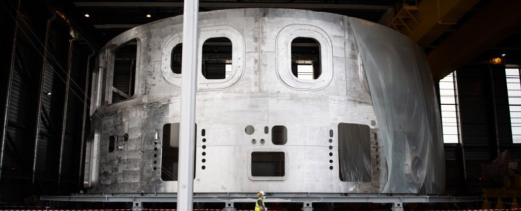 A technician walks past the cryostat. 