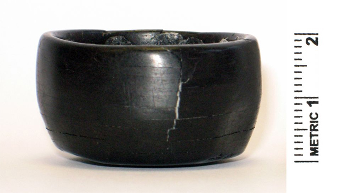 dark cylindrical object made of pottery  