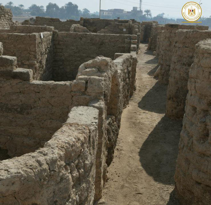 A neighborhood street of high walls in Egypt's 'Lost Golden City'