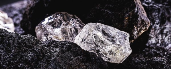 Rough diamonds sitting on black rocks