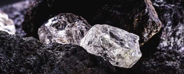 Rough diamonds sitting on black rocks