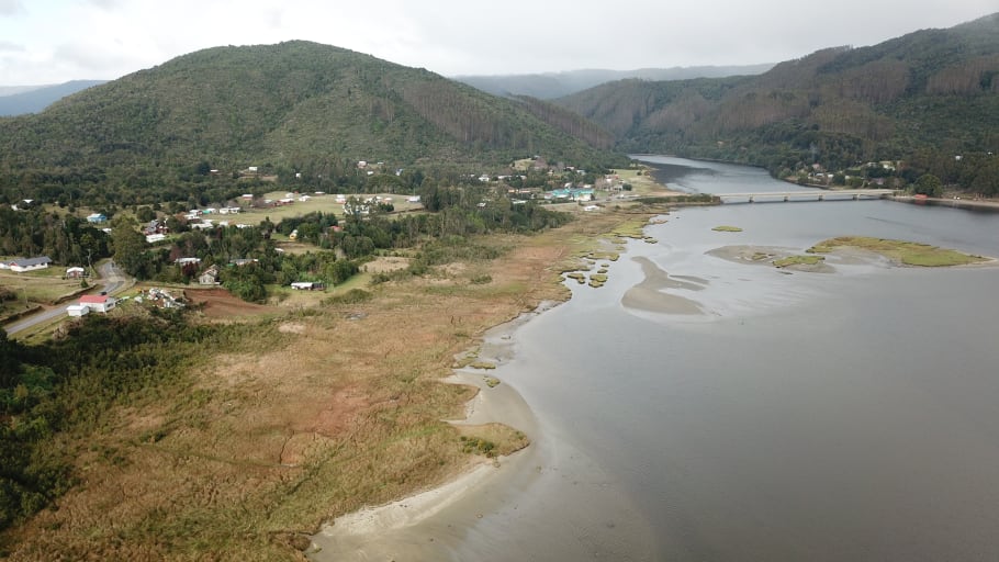 Misty hills with grey water in the foreground