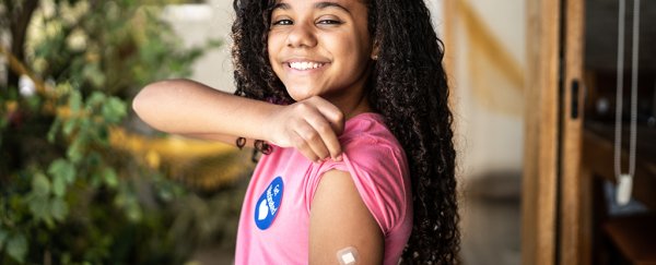 Girl holding up sleeve to show bandaid