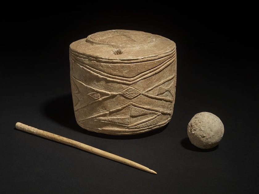 Decorated clay drum, ball and bone pin.