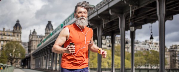 Grey haired man running in orange top