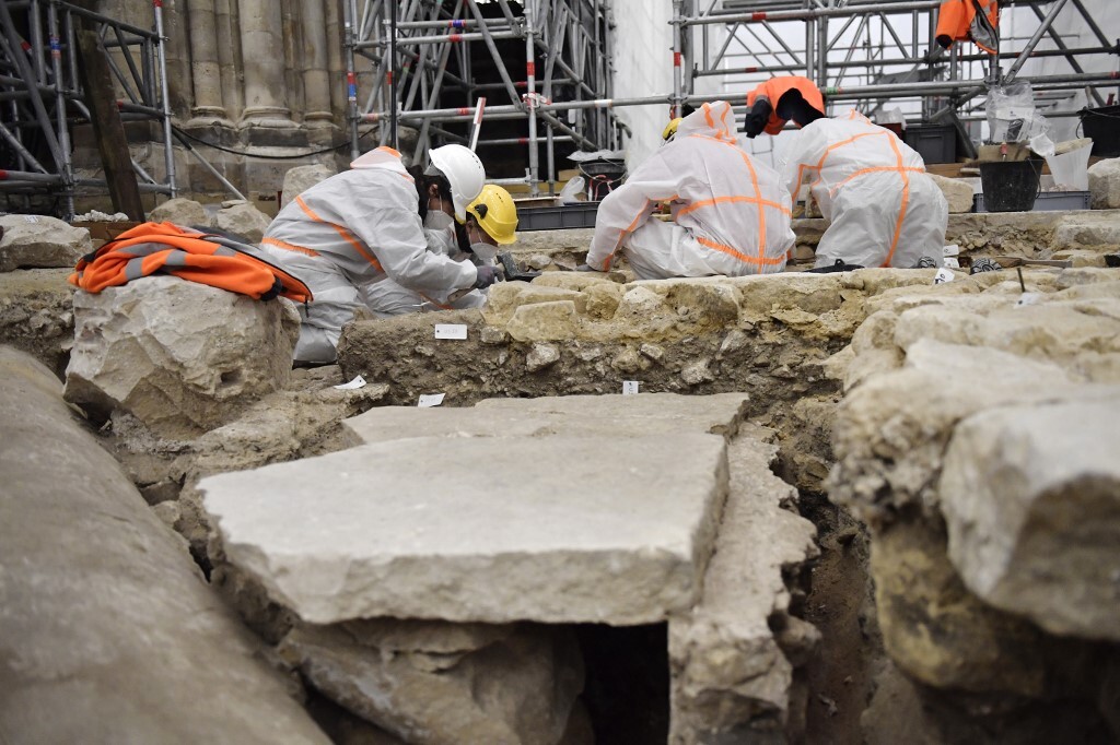 People in construction outfits excavating