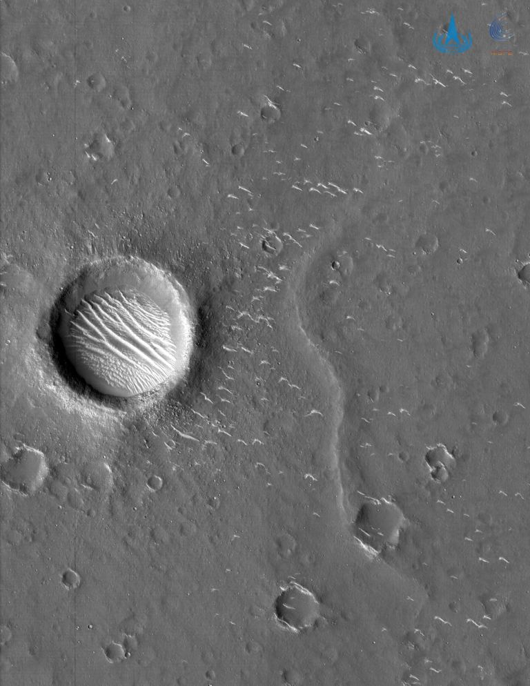 Black and white image of a circular crater on Mars, taken from above.