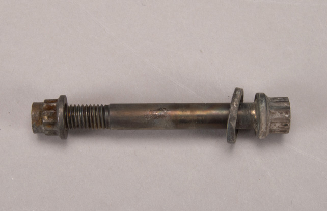 A bolt and washer on a beige surface.