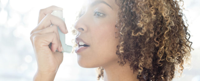 A woman using an inhaler