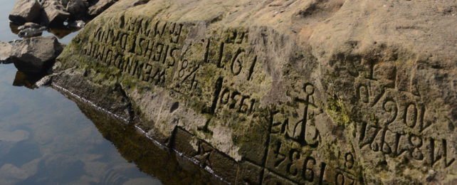 A 'hunger stone' with different letters on it on the banks of the Elbe River in the Decin, Czech Republic.
