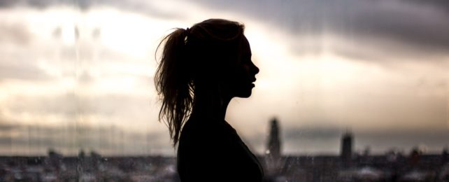 Woman Silhouetted Against Grey Sky