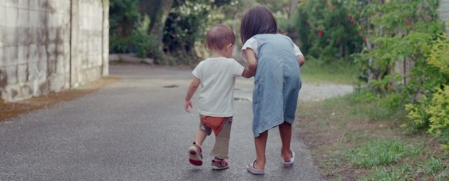 Young Japanese children walking on path