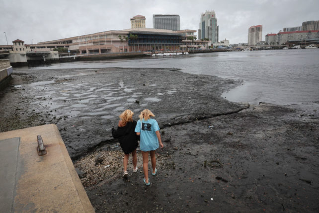 Two girls walk into an empty harbor.