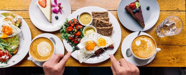 Man Eats Big Breakfast With Many Plates