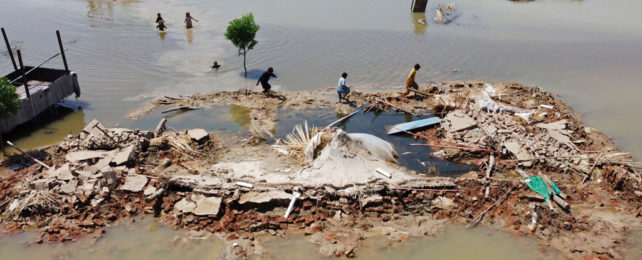 People navigate a flooded area in Pakistan.