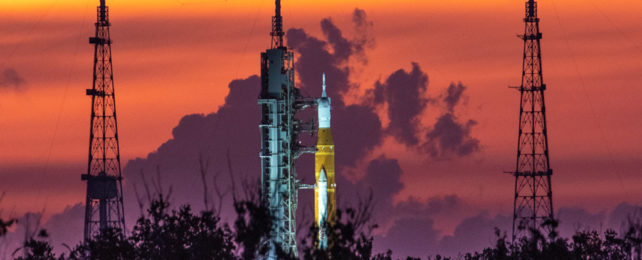 A rocket on a launchpad during sunrise.