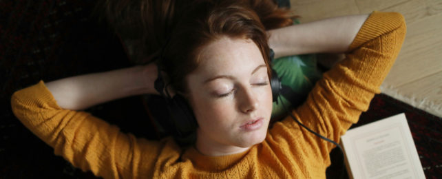 A sleeping woman wearing headphones.