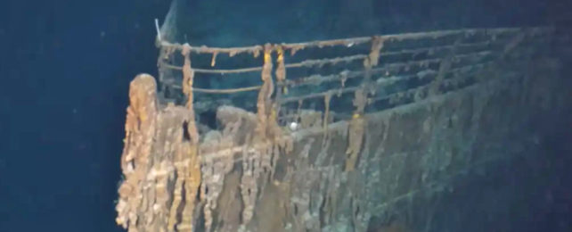 Titanic wreck emerging from darkness of the ocean.