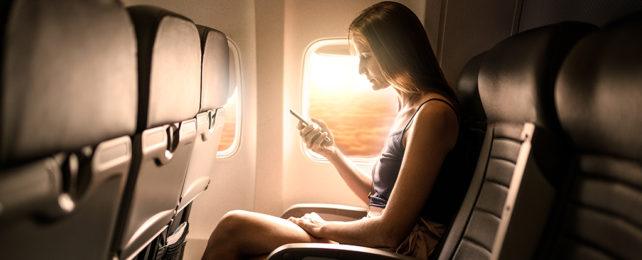 Woman on a plane holding a phone