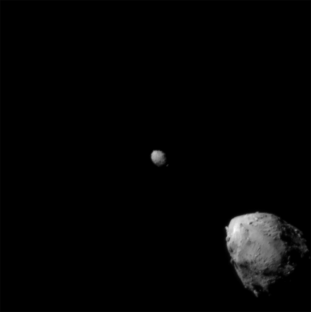 Black and white image showing two small rocks in space