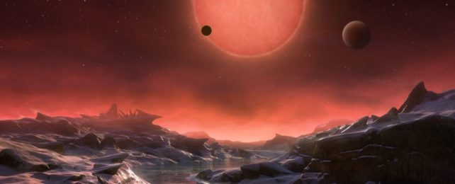 an illustration of a red dwarf star from the surface of an orbiting exoplanet with ice and water on the surface