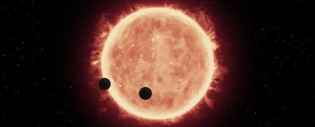 an artistic illustration of two exoplanets orbiting a red dwarf star