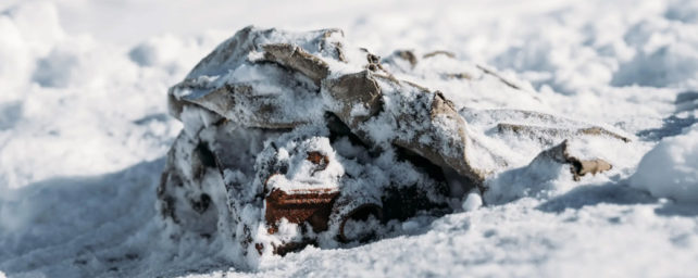 A 19th century camera case covered in snow on a glacier.