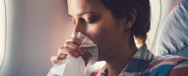 Person breathing into a sick bag