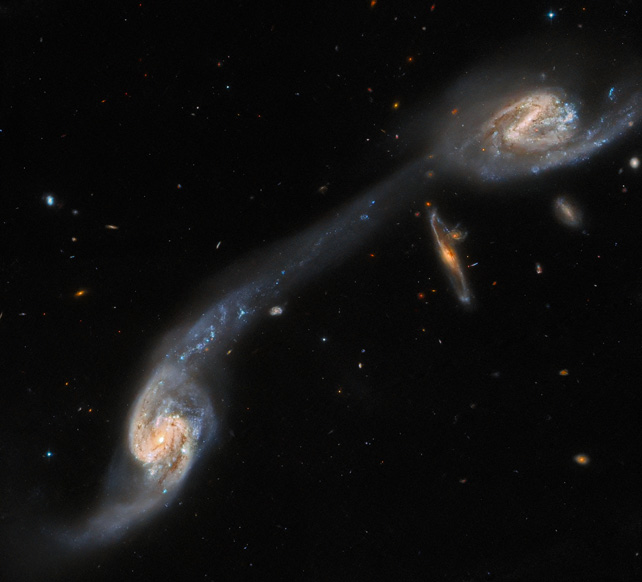 Bir gelgit kuyruğu ile birbirine bağlanan iki büyük sarmal gökadaya sahip gökada üçlüsü Arp 248.