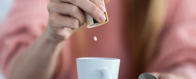 An artificial sweetener being dropped into a drink.