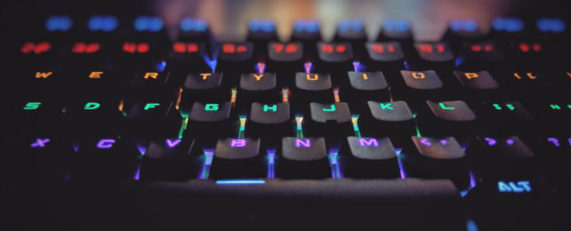 Computer keyboard with keys illuminated with coloured backlights, each row a different colour.