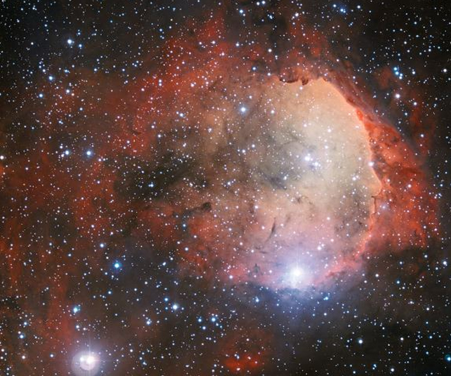 Un resplandor rojo de nubes que representan a NGC 3324