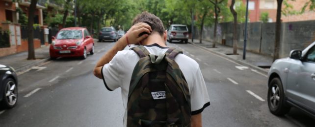 Teenage Boy Walks Down Street