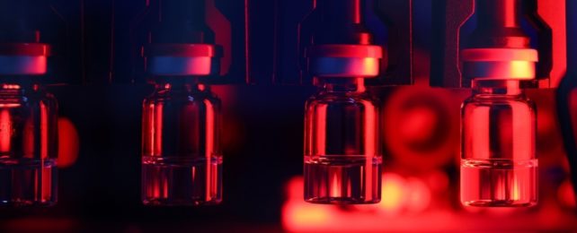 Vaccine vials in lab setting with red lighting