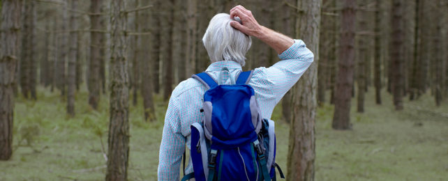hiker with blue backpack scratching head in confusion