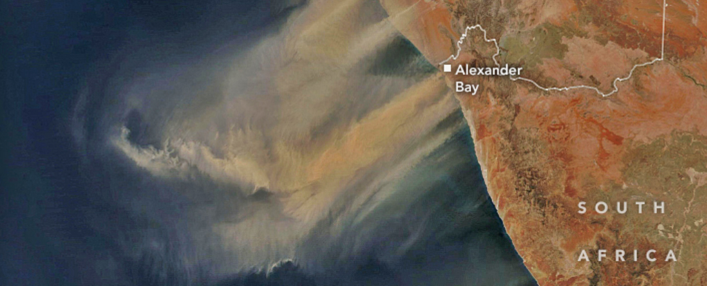 Hvirvler af brunt støv flyder over havet fra kontinentet