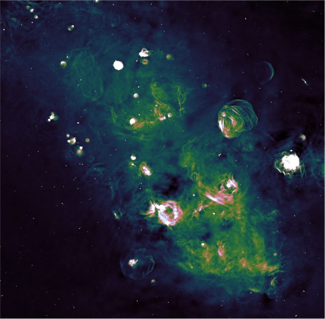 Zarcillos verdes detallados de gas que llenan los espacios entre las estrellas
