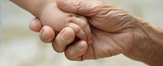 Young person and old person holding hands