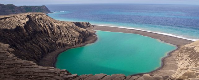 Volcanic Island In Ocean With Blue Waters