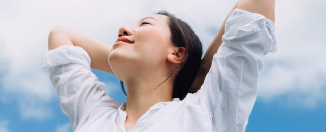 Woman In White Shirt Breathes Against Blue Sky