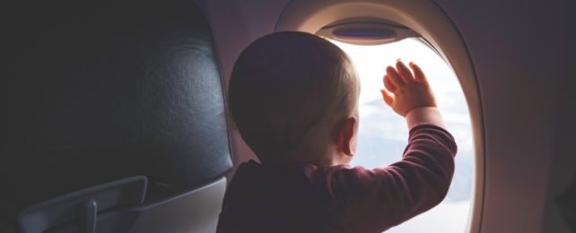 Young Child Touches Plane Window