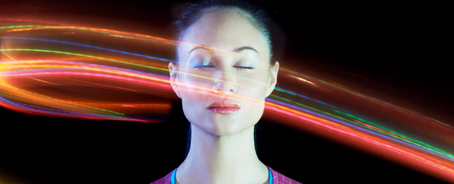 Person with their eyes closed and light swirling around their head